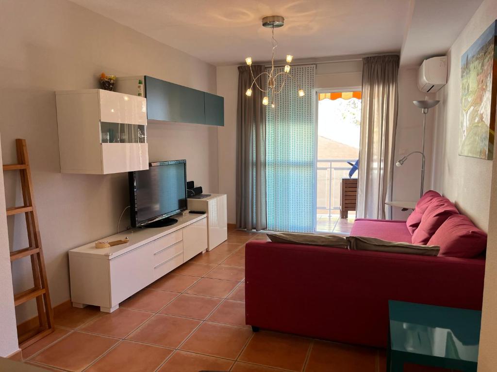 a living room with a couch and a flat screen tv at Balcón de la Torre del Morche en Torrox Costa in El Morche
