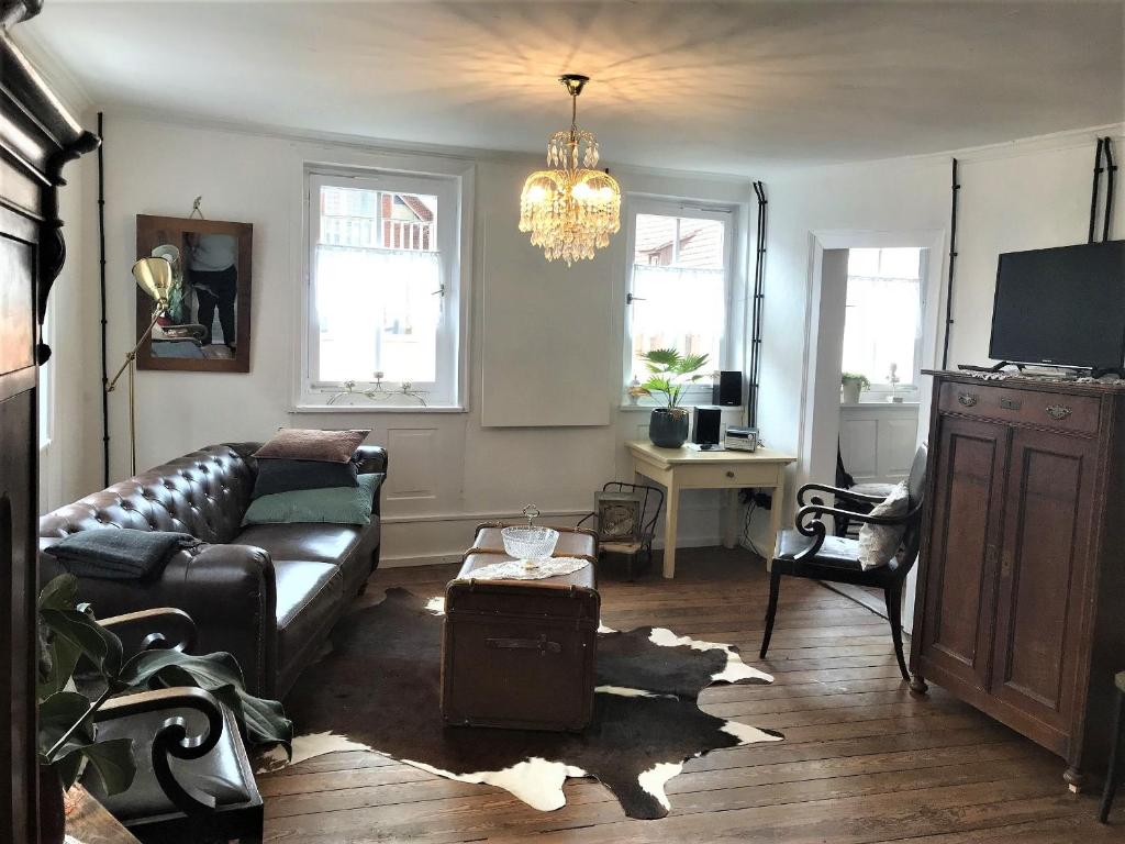 a living room with a couch and a chandelier at Ferienwohnung Bei Der Kirch in Münsingen