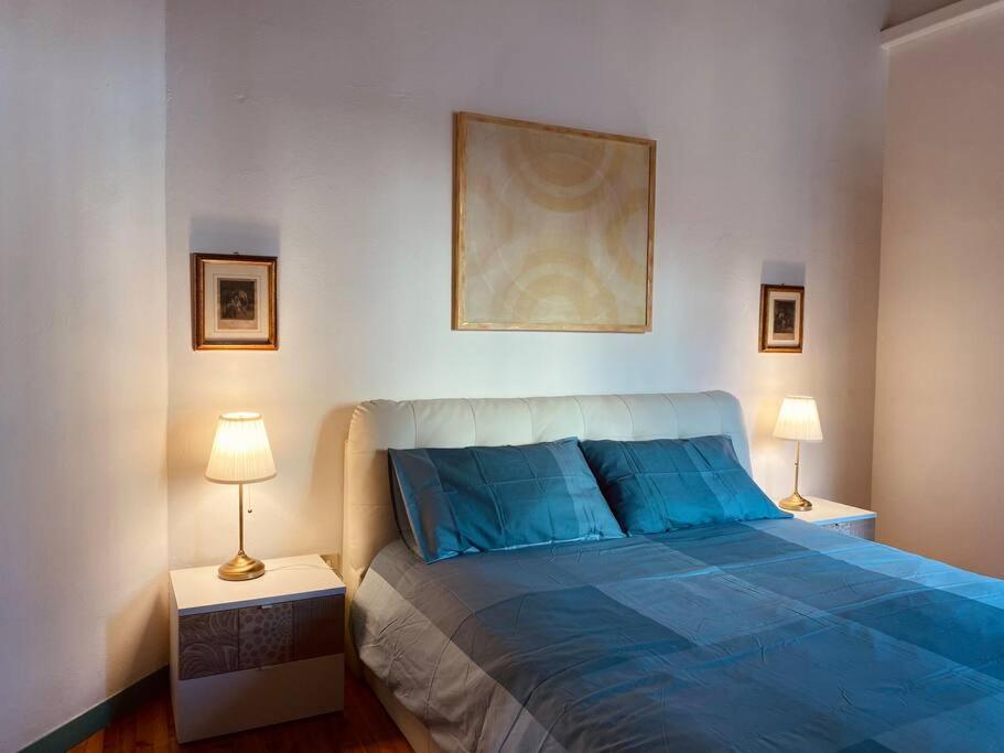 1 dormitorio con 1 cama azul y 2 lámparas en Portrait of Livorno en Livorno