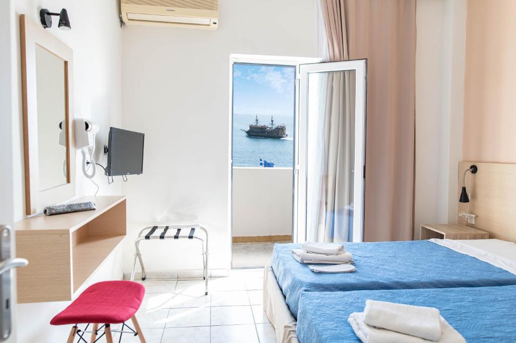 a bedroom with a bed and a view of the ocean at Achilleas Hotel Apartments in Kos Town