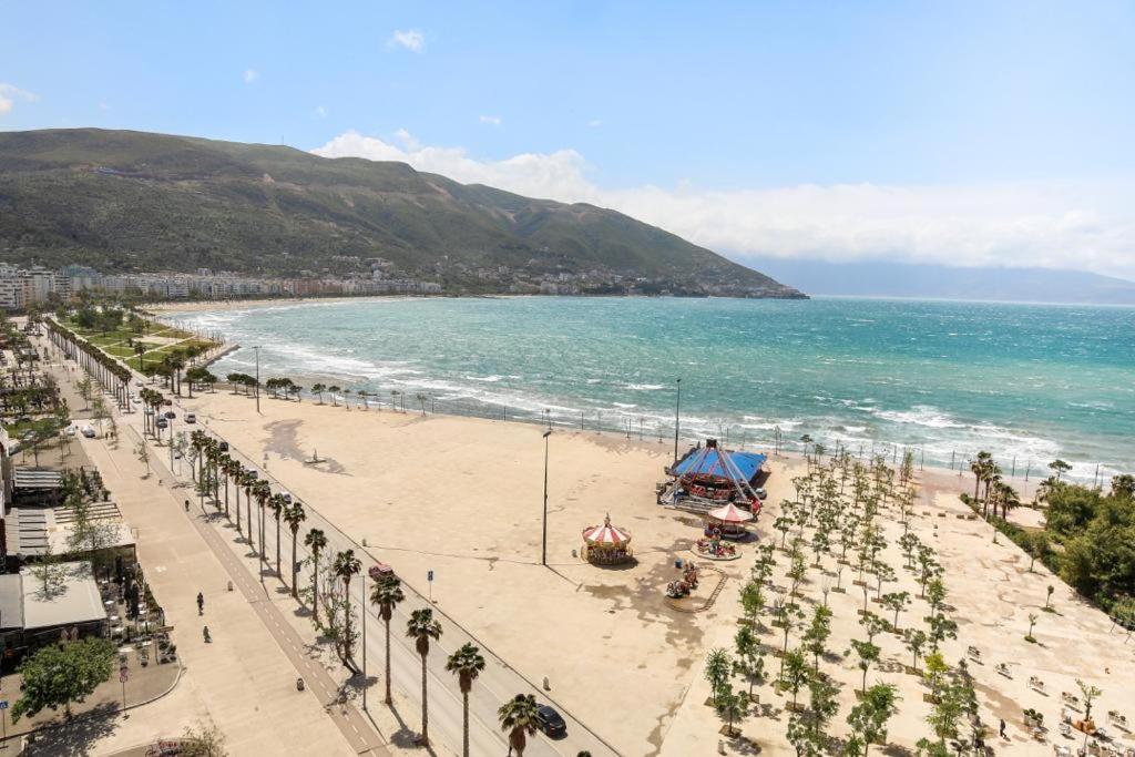 a view of a beach with palm trees and the ocean at Valbona Apartament's 2 in Vlorë