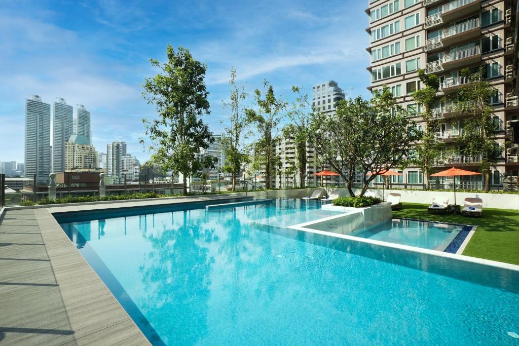 曼谷的住宿－SILQ Hotel & Residence, Managed by The Ascott Limited，一座位于城市的游泳池,有高大的建筑