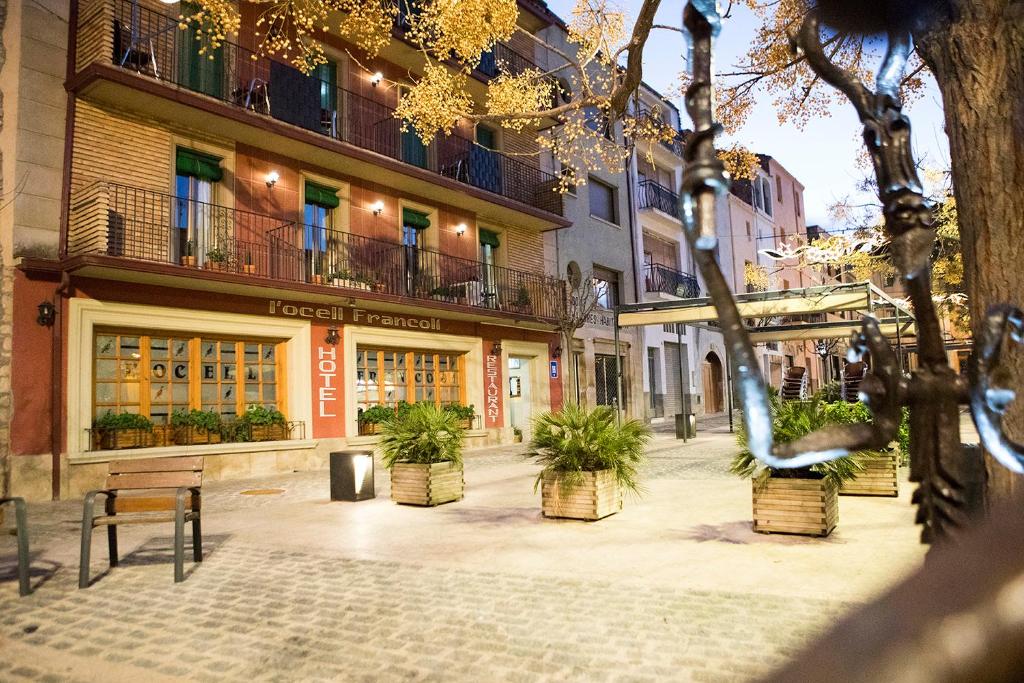 a street with potted plants in front of buildings at Hotel Rural Ocell Francolí in Espluga de Francolí