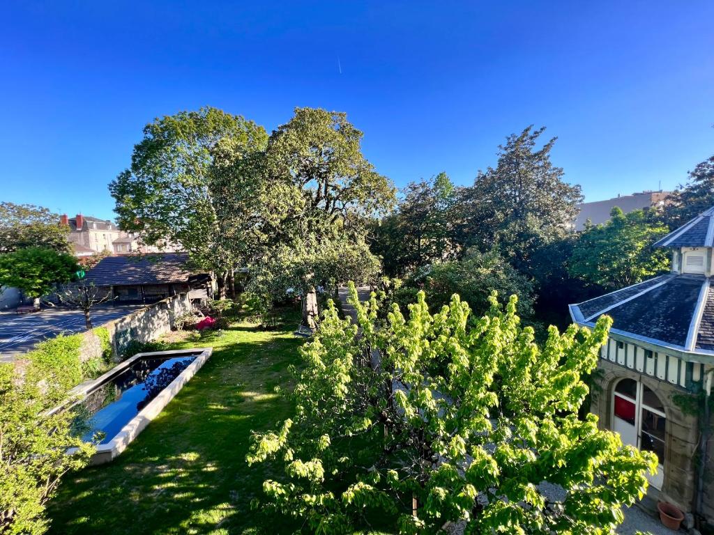 een luchtzicht op een tuin met een zwembad bij Demeure de Flore - Hôtel Particulier au Coeur de Brive comprenant 7 appartements de charme in Brive-la-Gaillarde