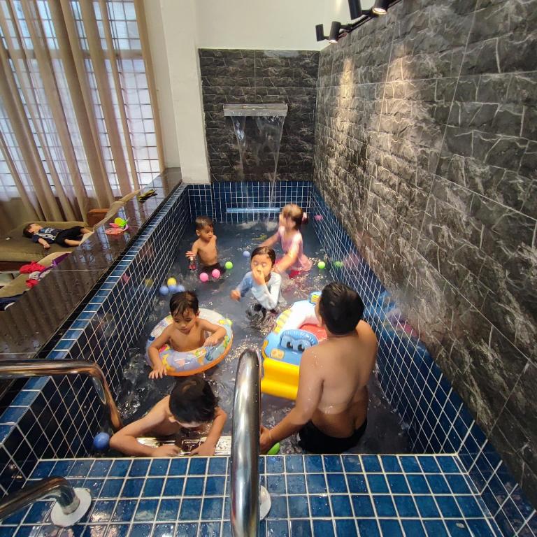 新山的住宿－HOMESTAY WEE INN JB，一群儿童在游泳池玩耍