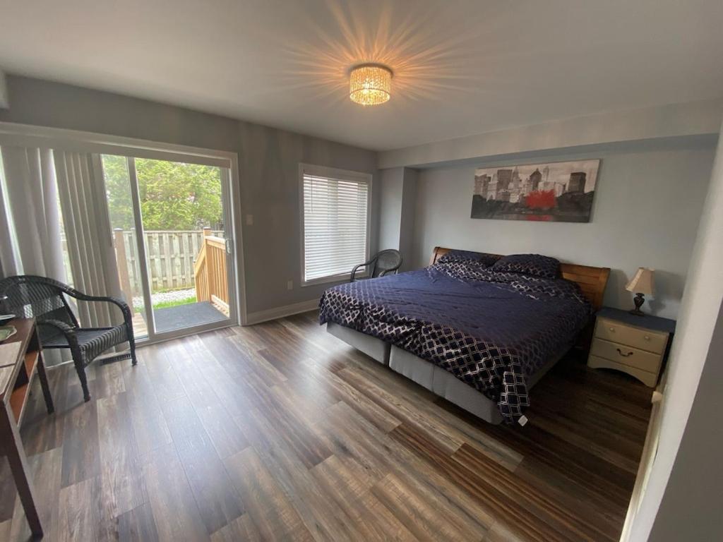 een slaapkamer met een bed en een houten vloer bij 2 bedroom with 2 ensuites Unit in Richmond Hill in Richmond Hill