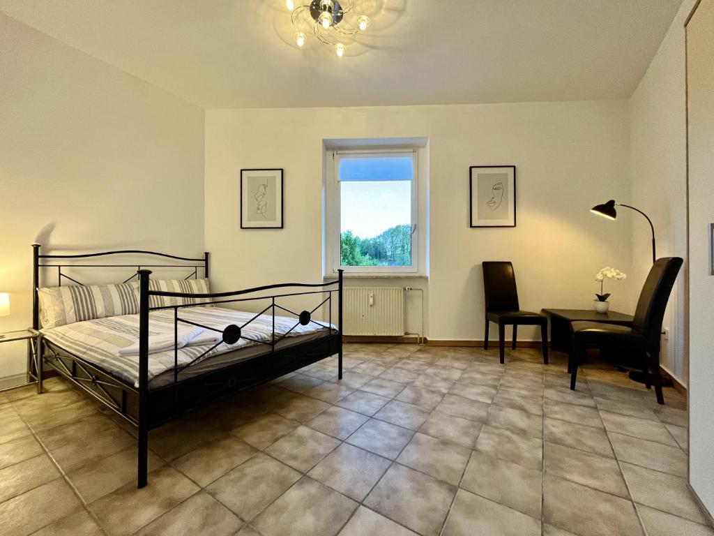 um quarto com uma cama, uma secretária e uma janela em Nostalgie Apartment - 3 Zimmer, 5 Betten, 7 Personen, kontaktloses Einchecken, Netflix em Wuppertal