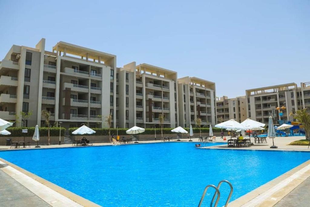 una gran piscina frente a un gran edificio en شاليه غرفتين سوبر لوكس, en Dawwār ‘Abd Allāh