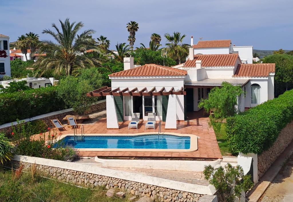 a villa with a swimming pool and a house at Villa Xalina - Piscina / bbq / jardín in Fornells