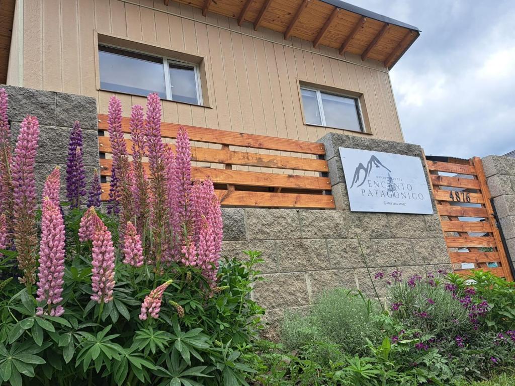 un jardín con flores púrpuras frente a un edificio en Encanto Patagónico en El Bolsón