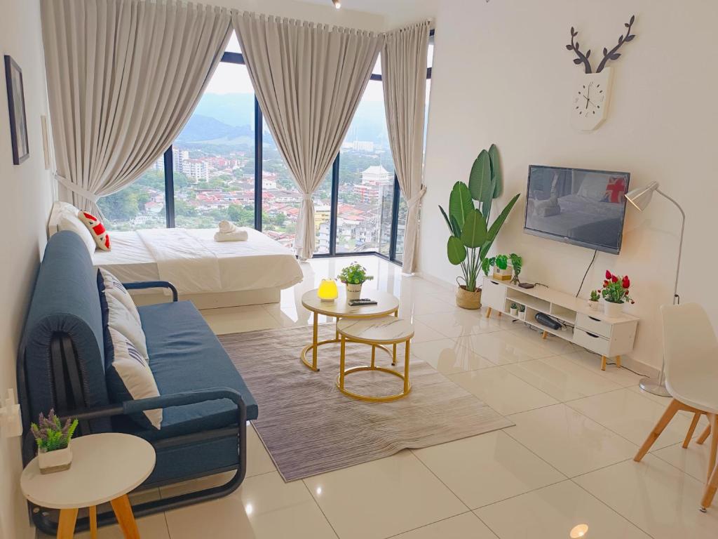 Rooftop Pool, Up to 8 Pax, 2 Bedrooms, 2 Bathrooms, 2 Car Parks by Star Home في جورج تاون: غرفة معيشة مع أريكة زرقاء ونافذة كبيرة