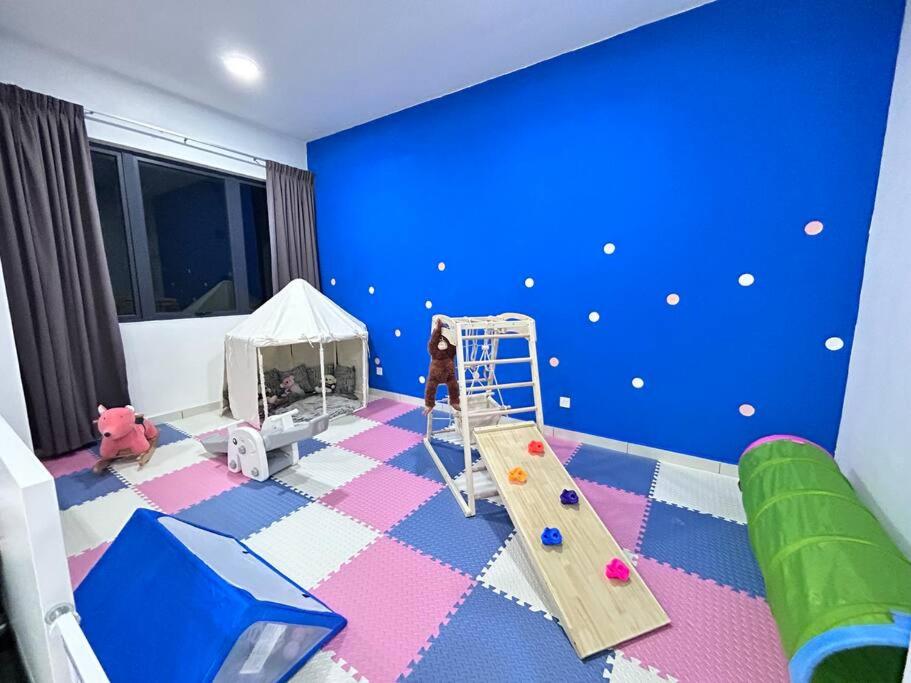 una camera per bambini con scivolo e parete blu di Semenyih kajang kiara plaza kids Land a Kajang