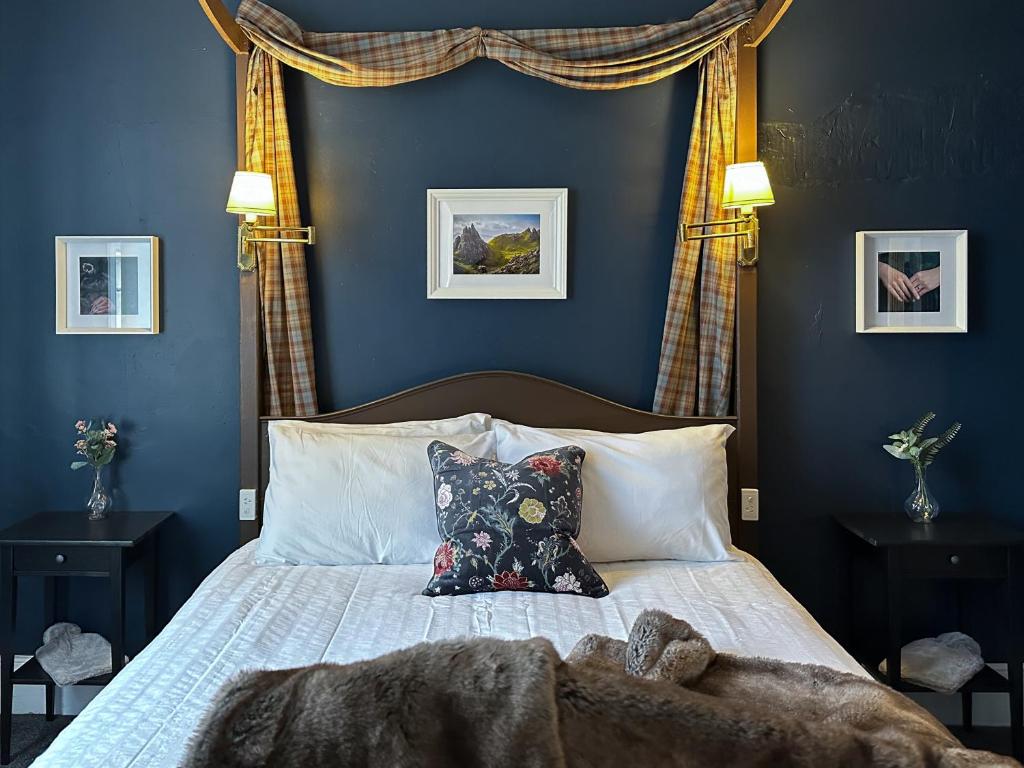 1 dormitorio con 1 cama con pared azul en Alice's Cottages en Launceston