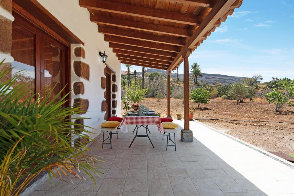 a patio with a table and chairs on a house at El Algarrobero in Santa Lucía