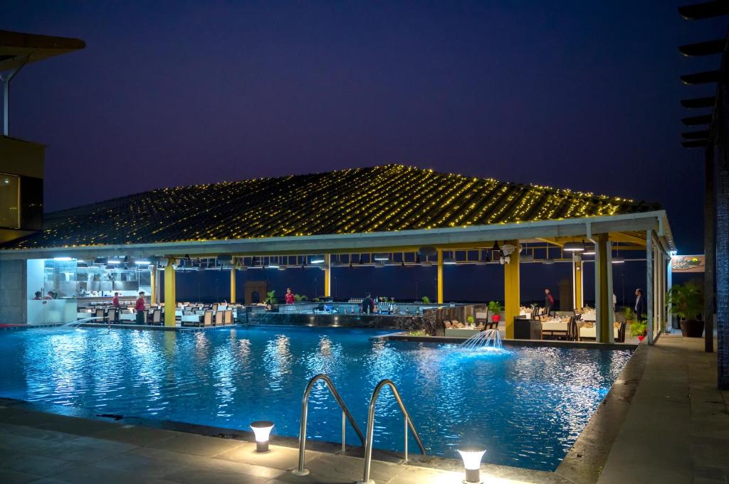 a swimming pool at night with a pavilion at The Gold Beach Resort in Daman