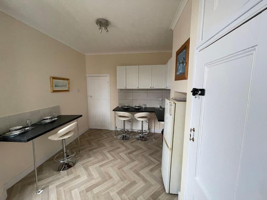 a kitchen with a counter and stools in it at Stunning 1 Bedroom Home in Southend-on-Sea