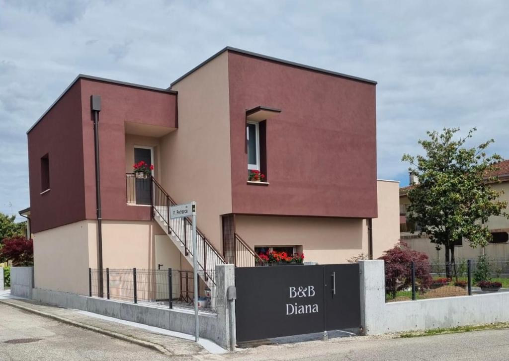 un edificio rojo con una escalera delante en B&B DIANA, en Pordenone
