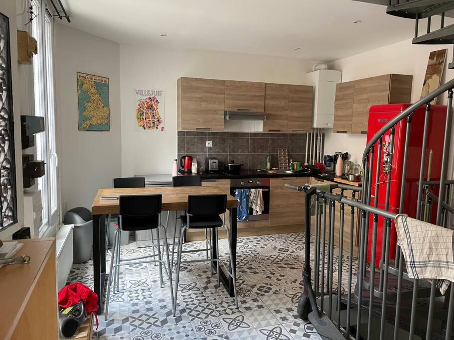 a kitchen with a table and chairs in a room at Maison 6 chambres Paris in Villejuif