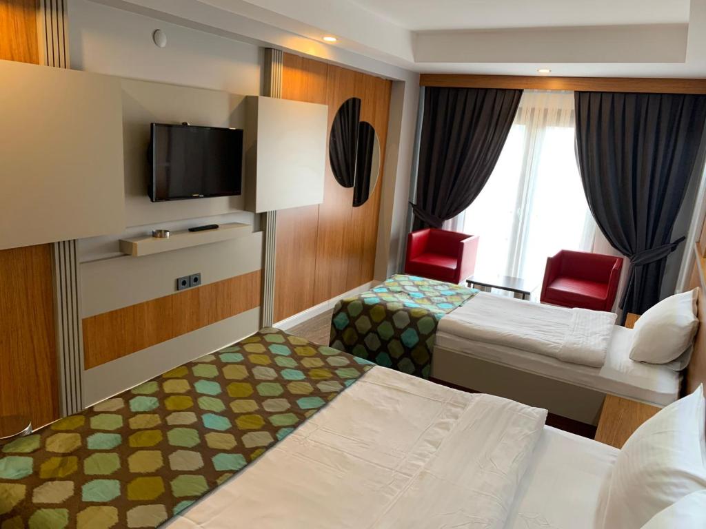 Habitación de hotel con 2 camas y TV de pantalla plana. en May park HOTEL, en Izmir