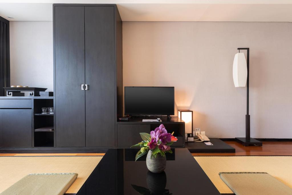 a living room with a vase of flowers on a table at Beitou Sweet Me Hot Spring Resort in Taipei