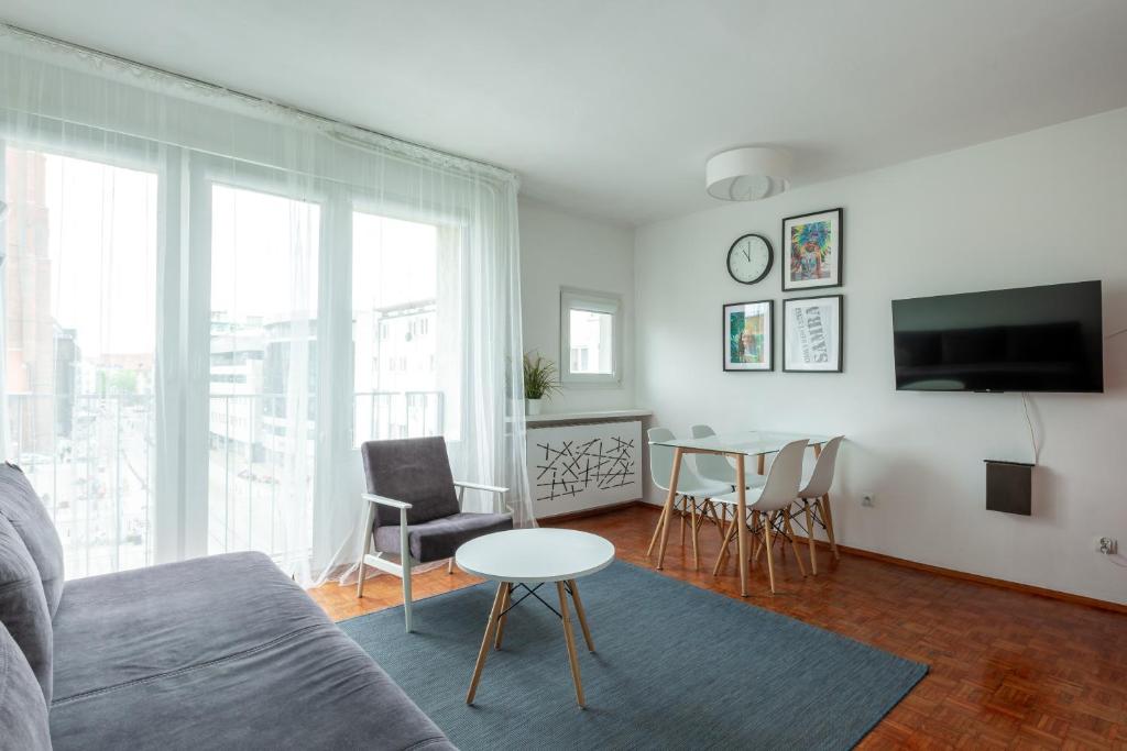 een woonkamer met een bank en een tafel bij Samba Apartment in Wrocław