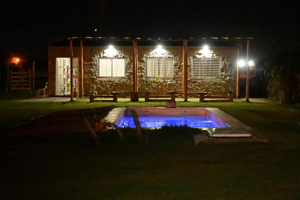 uma vista nocturna de um edifício com piscina em Aldea Cumelén em Campos Salles