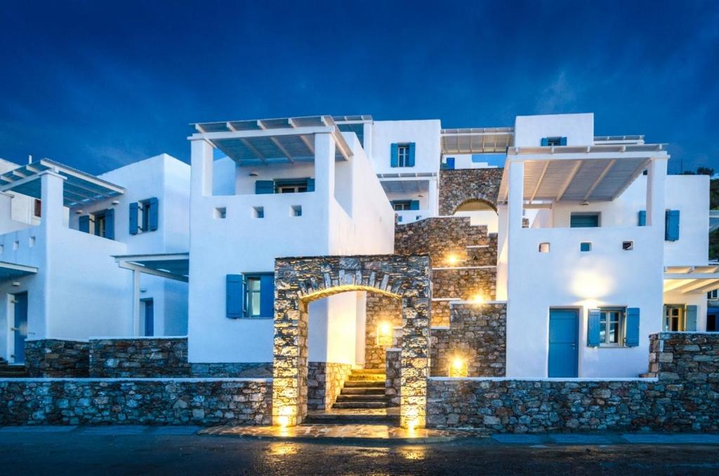 a building with a stone gate in front of it at night at Aelia Studios in Aegiali