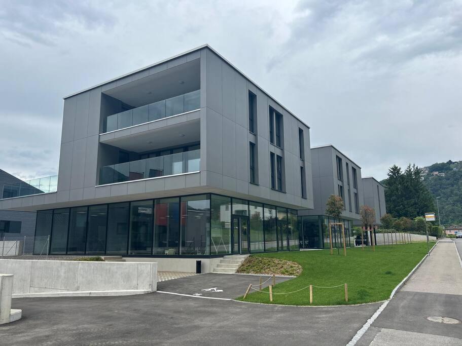 un grand bâtiment gris avec beaucoup de fenêtres dans l'établissement LabPark design apartment, à Melano