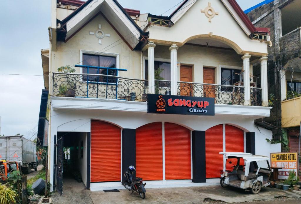 a house with red garage doors and a scooter parked in front at RedDoorz @ near Caticlan Port in Aklan