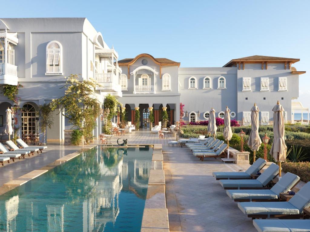 een resort met een zwembad en ligstoelen bij La Maison Bleue El Gouna in Hurghada