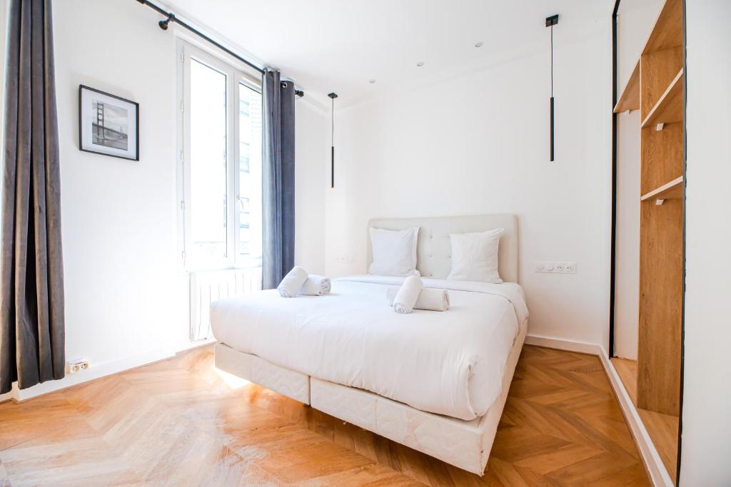 パリにあるResidence Élyséesの大きな窓付きの客室の白いベッド1台
