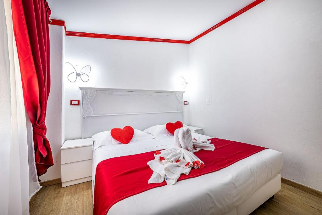 a bedroom with a bed with red hearts and white sheets at ḤỌṬẸḶ ṾẸṆẸṬỌ con accesso ZTL in Florence