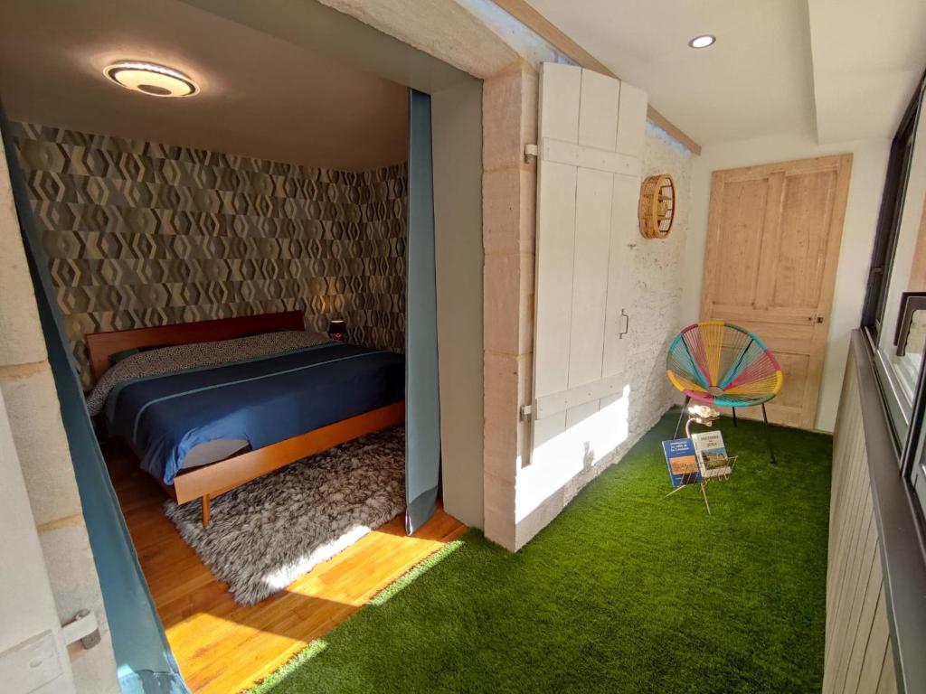 a bedroom with a bed and a room with green grass at Logis 39 in Champagnole