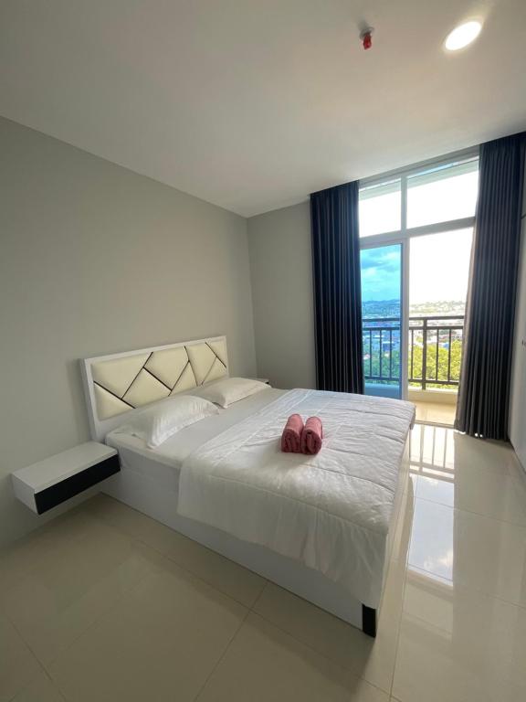 a bedroom with a bed with two pink shoes on it at FORMOSA RESIDENCE NAGOYA -The Apartments 1 Bed Room 173A in Nagoya