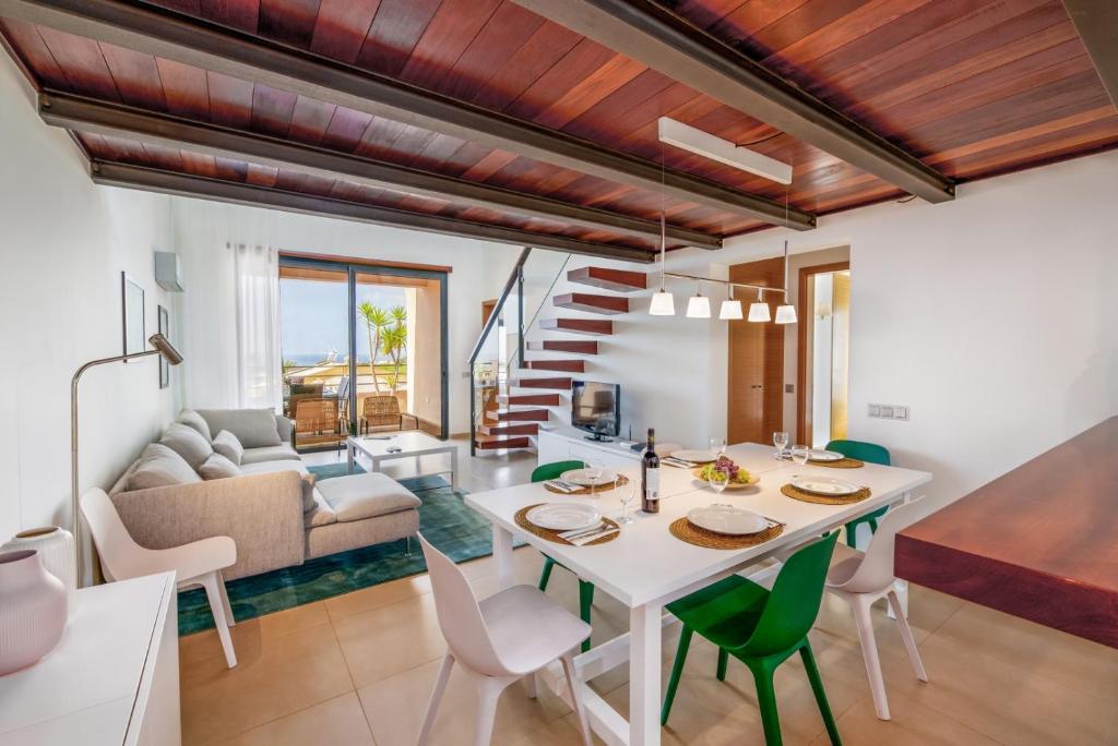 a kitchen and living room with a table and chairs at Mar da Luz Resort in Luz