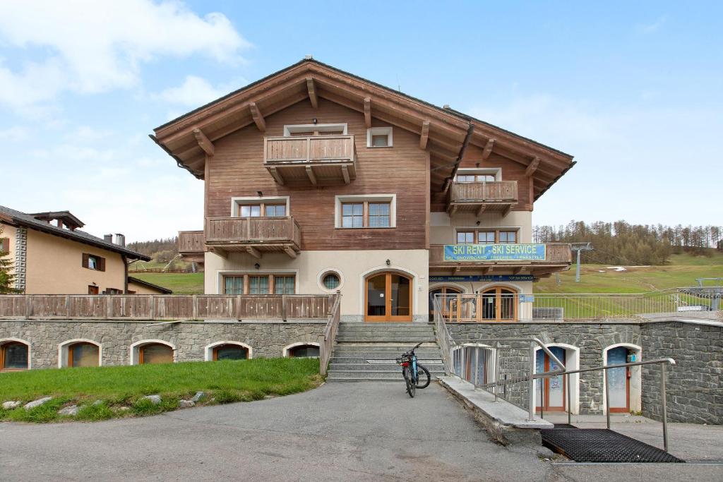 una casa con techo de madera y una bicicleta aparcada delante en Baita Valandrea 3, en Livigno
