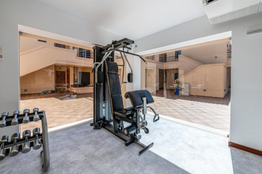 a gym with a treadmill and a chair in a room at Mar da Luz Resort in Luz