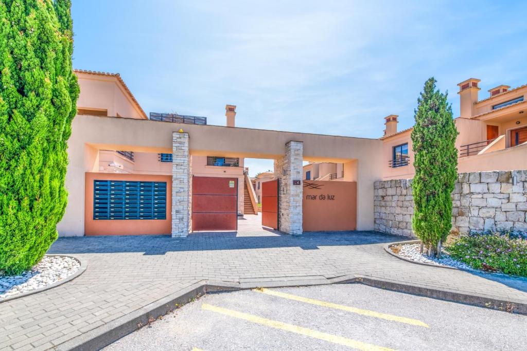 a large house with a garage and trees at Mar da Luz Resort in Luz