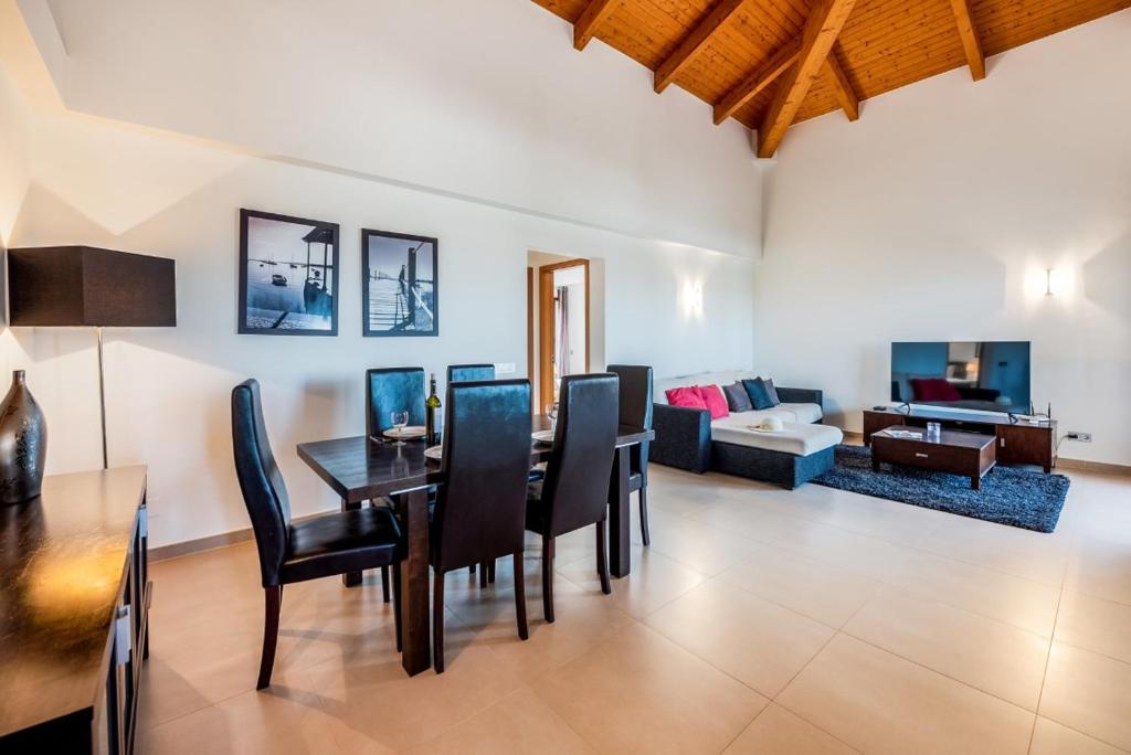 a dining room and living room with a table and chairs at Mar da Luz Resort in Luz