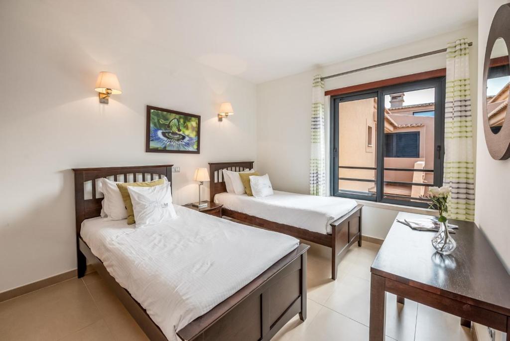 a hotel room with two beds and a window at Mar da Luz Resort in Luz