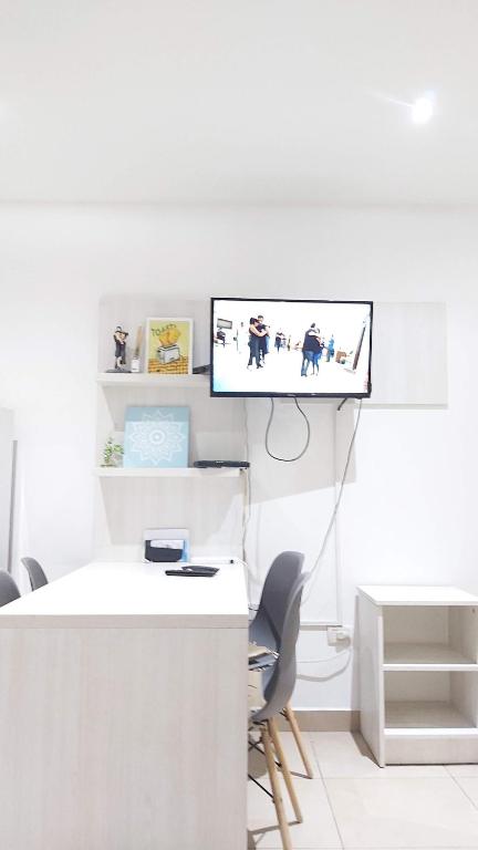 biuro z biurkiem i telewizorem na ścianie w obiekcie Abrazo Fueguino: calido comodo y centrico -WiFi w mieście Ushuaia