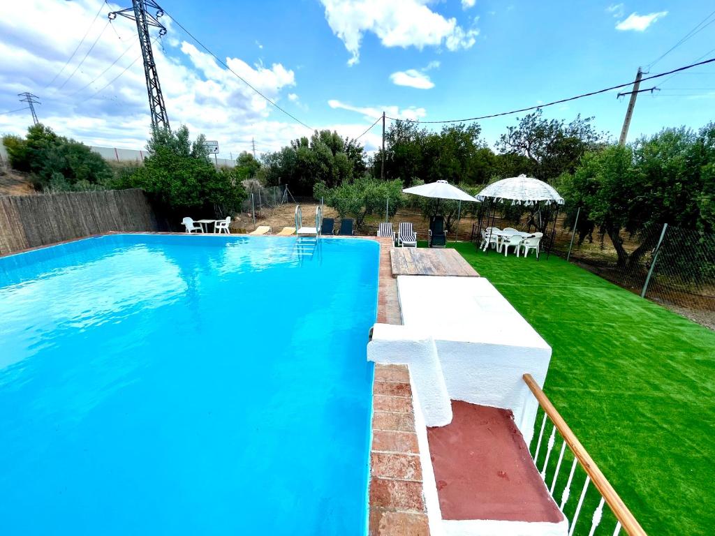 a swimming pool in a yard with tables and umbrellas at Mas de la Maria in Cambrils