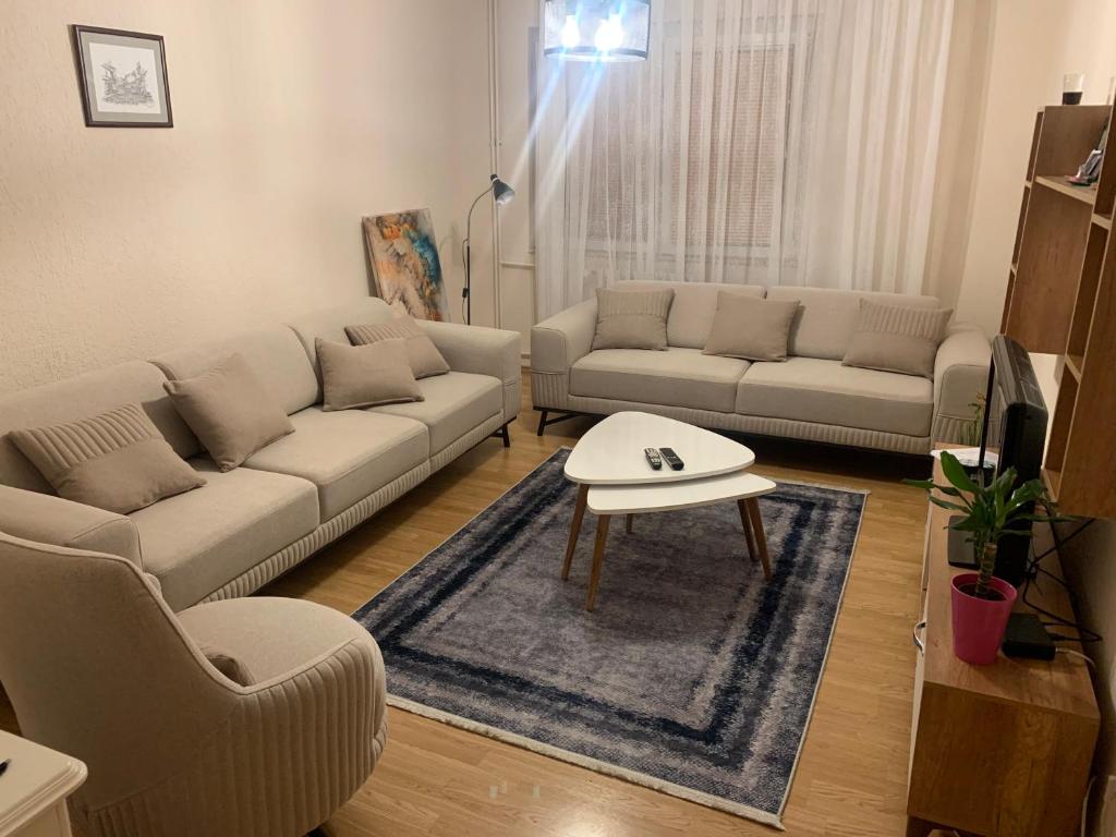 a living room with a couch and a coffee table at Comfortable apartment close to the city center in Prishtinë