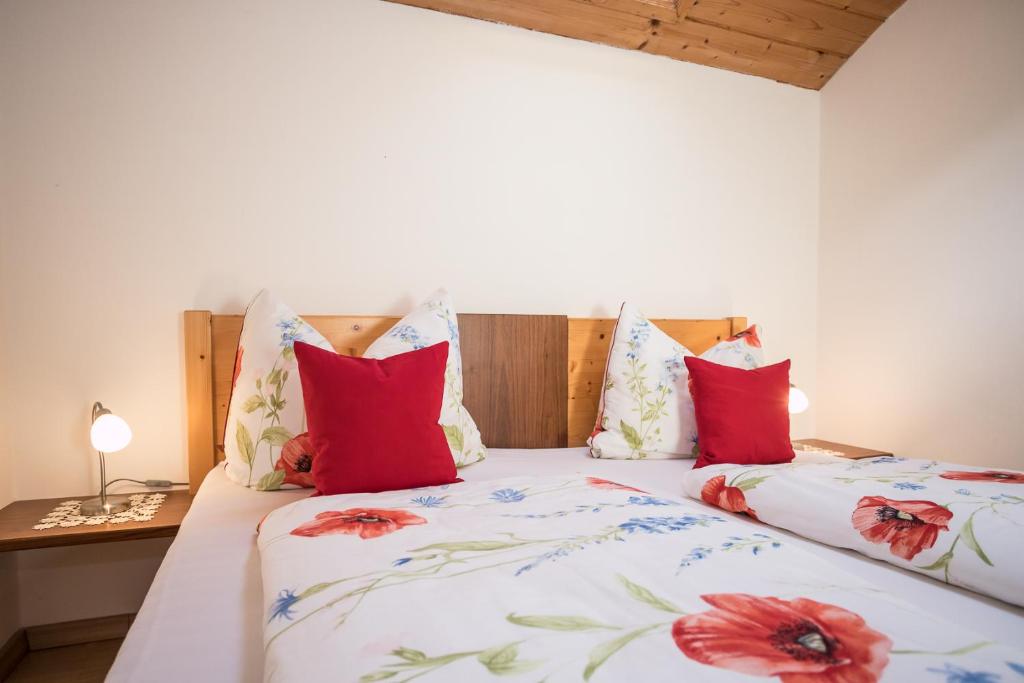1 dormitorio con 2 camas y almohadas rojas en Moarhof Gufidaun, en Chiusa