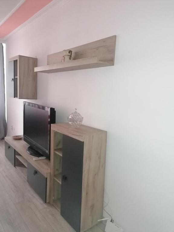 a living room with a tv and a wooden cabinet at Garsoniera P2 in Craiova