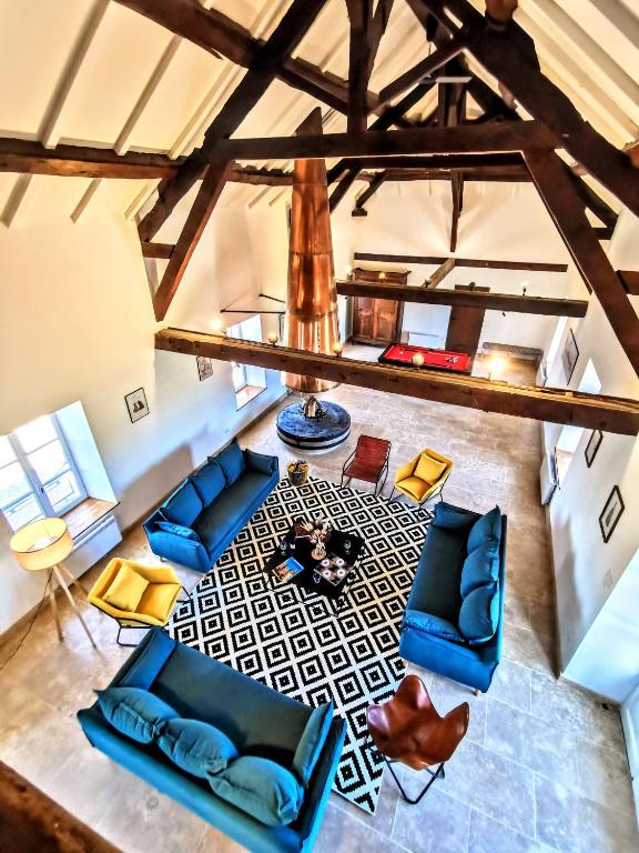 - un salon avec un mobilier bleu dans l'établissement Moulin des ducs grand format by Vindihouses - piscine chaffée - escalade - billard - fitness - etc, à Épinac-les-Mines