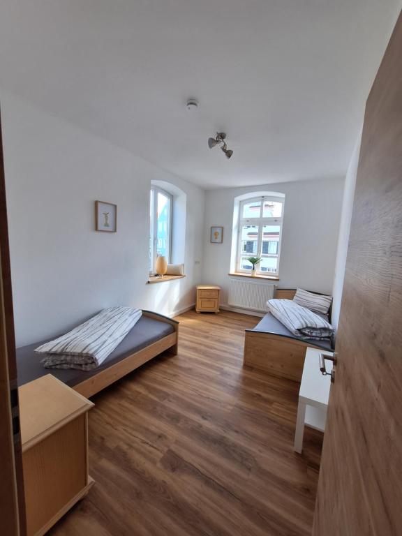 two beds in a room with wooden floors at Gasthof Adler Ferienwohnung in Ichenhausen