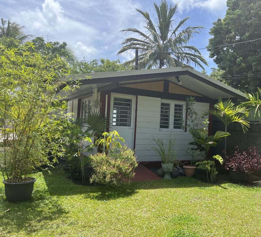 une petite maison avec des plantes dans une cour dans l'établissement Pare LODGE TAHITI, à Pirae