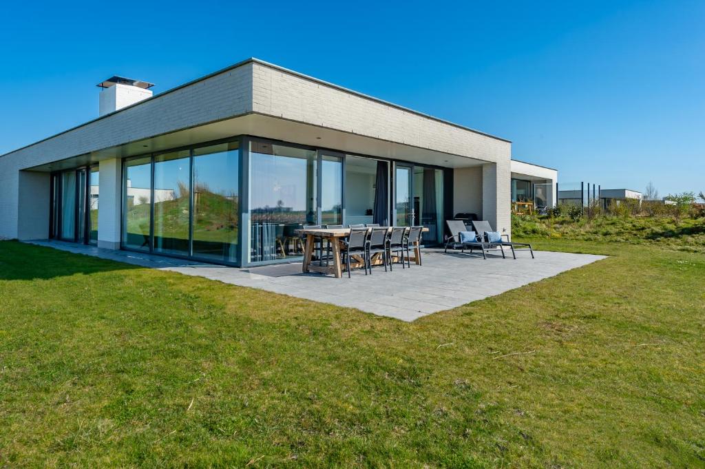 a house with a patio with a table and chairs at De Groote Duynen in Kamperland