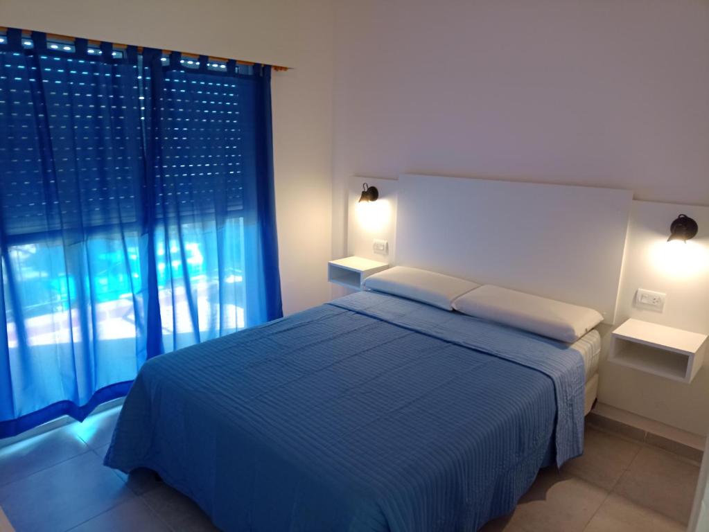 a bedroom with a blue bed and a window at Departamento en primer piso in Venado Tuerto